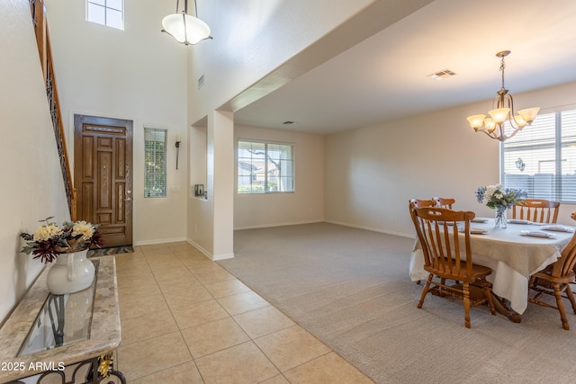 dining space featuring light tile patterned floors, light colored carpet, visible vents, and a healthy amount of sunlight