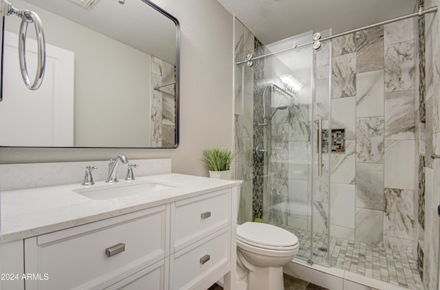 bathroom featuring vanity, toilet, and an enclosed shower