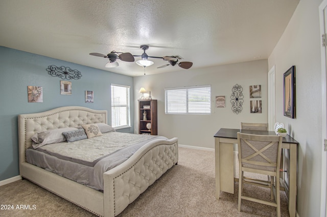 carpeted bedroom featuring ceiling fan and a textured ceiling