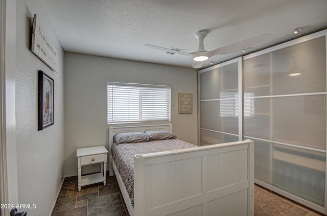 unfurnished bedroom featuring ceiling fan and a textured ceiling