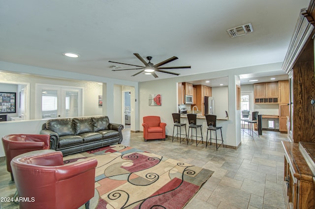 living room featuring a wealth of natural light and ceiling fan