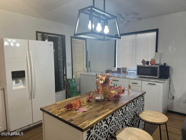 404 E Forest Dr, Payson, AZ 85541 - kitchen with white refrigerator with ice dispenser, stainless steel microwave, wood counters, dark wood-style floors, and white cabinetry