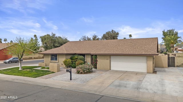 ranch-style house with a garage, fence, concrete driveway, roof with shingles, and a gate