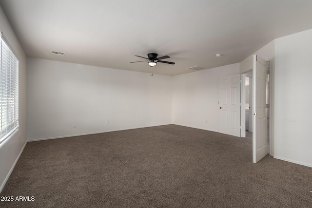 carpeted empty room featuring baseboards, ceiling fan, and visible vents