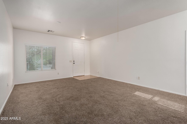 empty room with visible vents, carpet, and baseboards