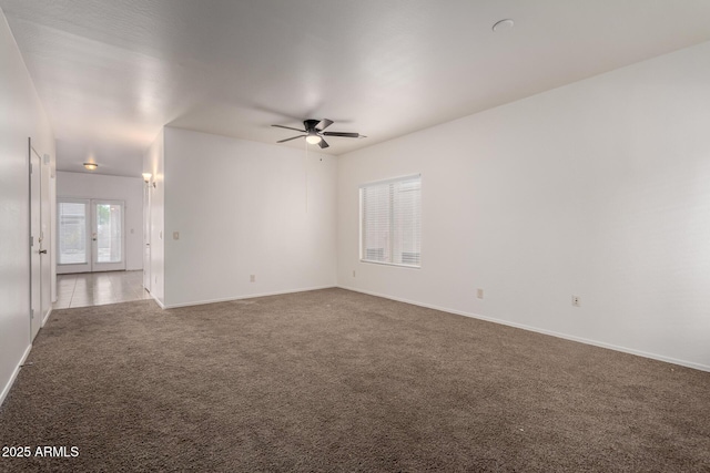 carpeted empty room with baseboards and ceiling fan