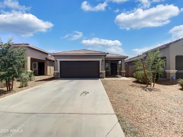 35337 W San Alvarez Ave, Maricopa, AZ 85138 - view of front of home featuring stucco siding, a garage, concrete driveway, and stone siding
