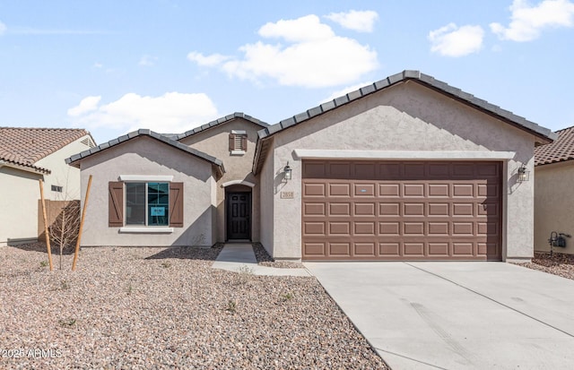 view of front facade featuring a garage, a tile roof, driveway, and stucco siding