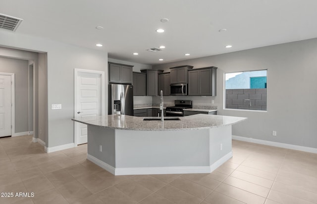 2851 N Coronado Dr, Florence, AZ 85132 - kitchen with light stone countertops, visible vents, a kitchen island with sink, and appliances with stainless steel finishes