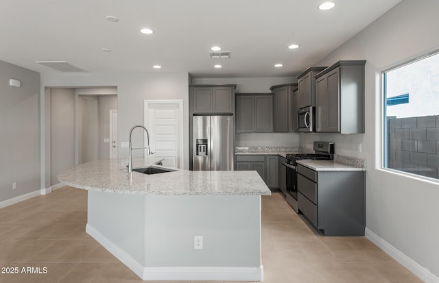 2851 N Coronado Dr, Florence, AZ 85132 - kitchen featuring light stone counters, stainless steel appliances, a sink, gray cabinets, and a center island with sink