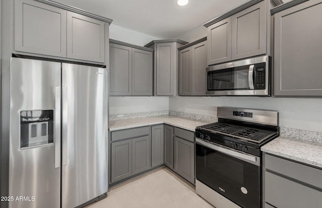 2851 N Coronado Dr, Florence, AZ 85132 - kitchen with light tile patterned floors, appliances with stainless steel finishes, gray cabinets, and light stone counters