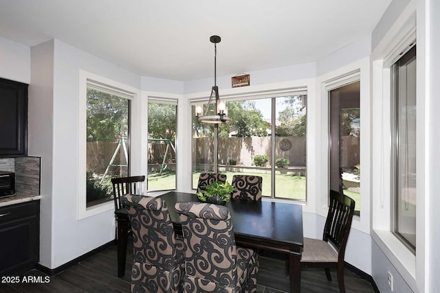 dining area featuring healthy amount of natural light, dark wood-style flooring, and baseboards