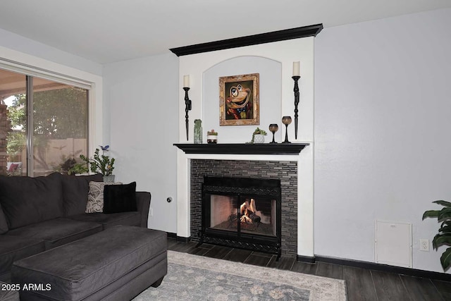 living area featuring wood finished floors and a fireplace with flush hearth