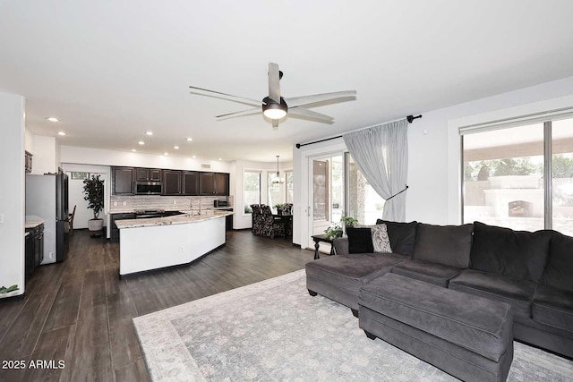 living room with ceiling fan, recessed lighting, and dark wood-style floors