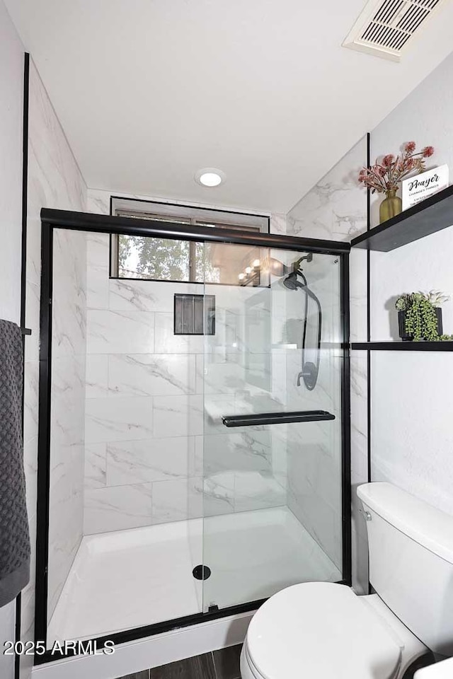 bathroom with toilet and a shower stall