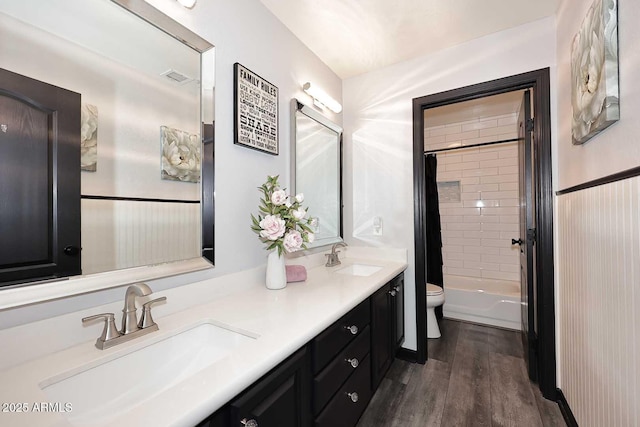 full bath with toilet, wood finished floors, double vanity, and shower / tub combo with curtain