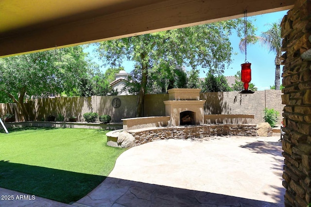 view of patio / terrace featuring exterior fireplace and a fenced backyard