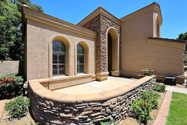 view of front of house featuring stucco siding and stone siding