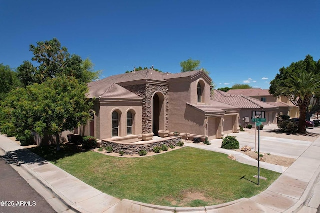 mediterranean / spanish house with a tiled roof, stucco siding, concrete driveway, a garage, and a front yard