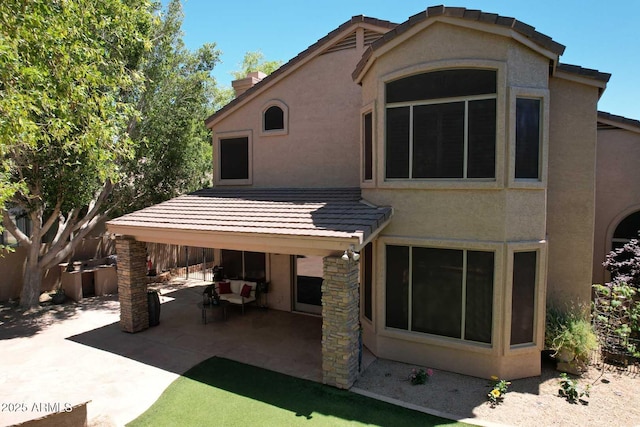 back of house with stucco siding, a patio, and a tiled roof