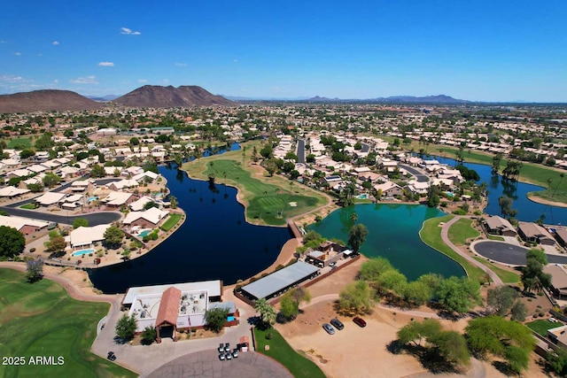 aerial overview of property's location featuring nearby suburban area, a water and mountain view, and a golf course
