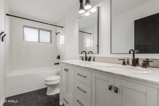 full bathroom featuring double vanity, tile patterned flooring, a sink, and toilet