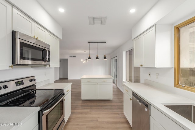 kitchen with visible vents, white cabinets, appliances with stainless steel finishes, light countertops, and pendant lighting