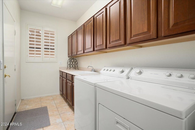 washroom featuring cabinets, washer and clothes dryer, sink, and light tile patterned floors