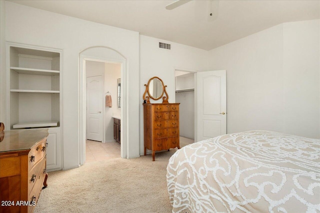 carpeted bedroom featuring connected bathroom and ceiling fan