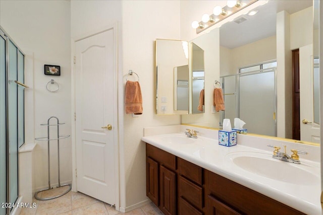 bathroom featuring tile patterned flooring, vanity, and a shower with door