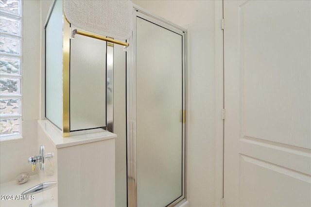 bathroom featuring a shower with shower door