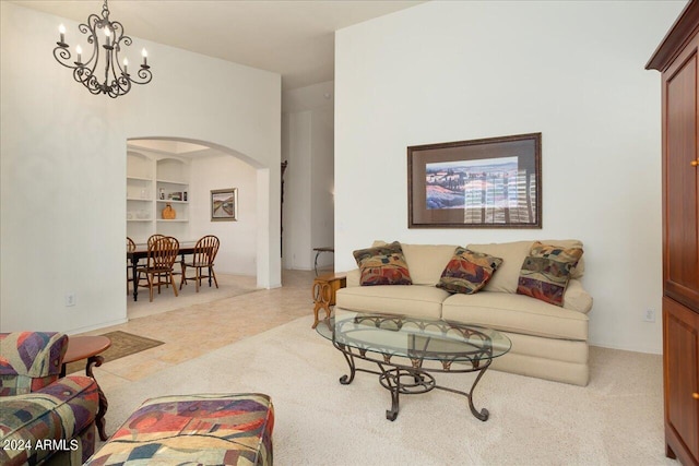 living room featuring built in features, light carpet, and a chandelier