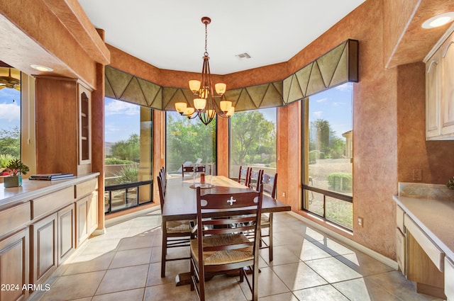 dining area with a healthy amount of sunlight, an inviting chandelier, and light tile patterned flooring