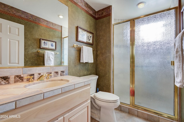 bathroom with vanity, toilet, tile patterned flooring, and a shower with door