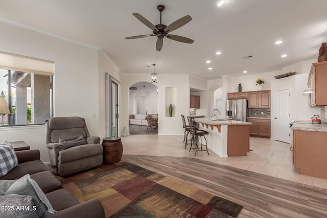 living room with visible vents, a ceiling fan, light tile patterned flooring, recessed lighting, and arched walkways