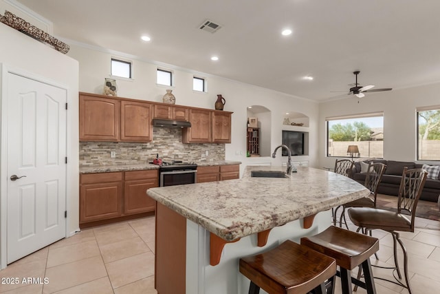 kitchen with visible vents, stainless steel range with electric cooktop, a sink, light tile patterned floors, and ornamental molding