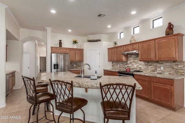 kitchen with visible vents, ornamental molding, under cabinet range hood, and stainless steel appliances