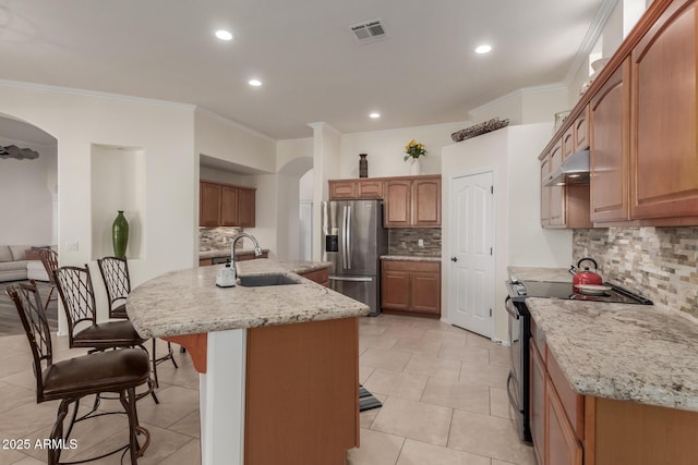 kitchen featuring arched walkways, a sink, black electric range oven, and stainless steel fridge with ice dispenser