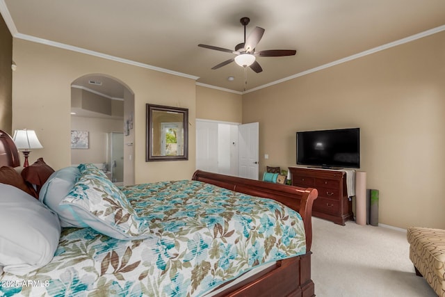 bedroom with visible vents, ornamental molding, light carpet, arched walkways, and a ceiling fan