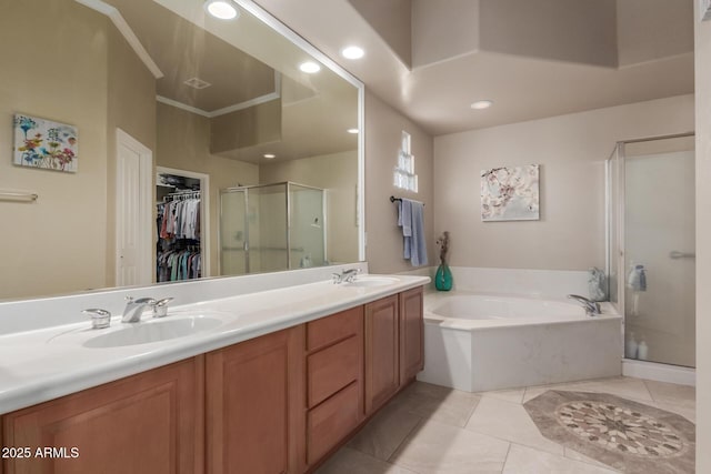 full bath featuring double vanity, a bath, a spacious closet, a sink, and a stall shower