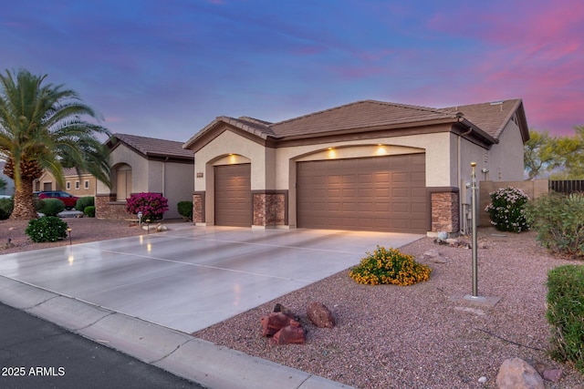 view of front of house featuring a garage, stucco siding, driveway, and a tiled roof