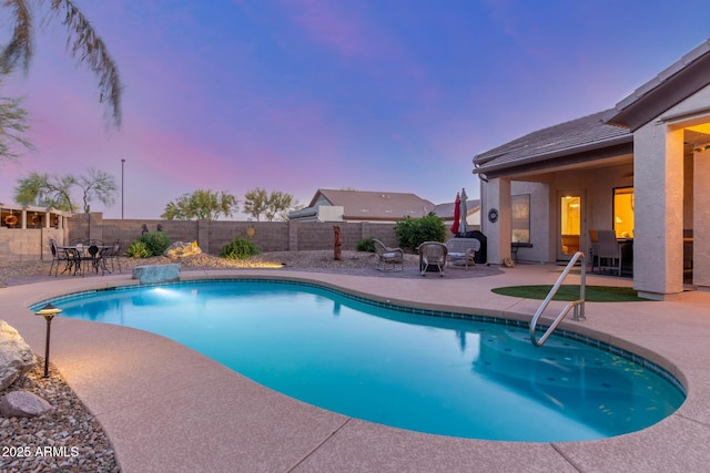 view of swimming pool with a patio, a fenced backyard, a fenced in pool, and outdoor dining space