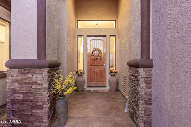 doorway to property featuring stucco siding