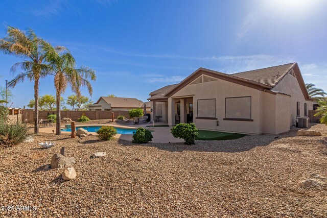 rear view of property featuring a fenced backyard, a fenced in pool, stucco siding, and a patio area