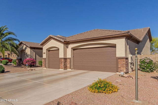 view of front facade featuring an attached garage, stone siding, stucco siding, concrete driveway, and a tiled roof