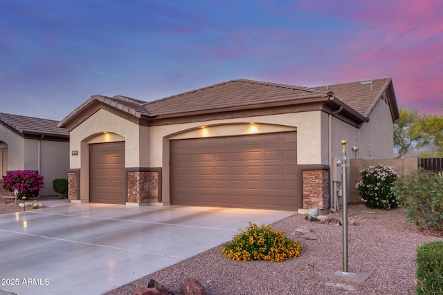 view of front of home with a garage, fence, stucco siding, and driveway