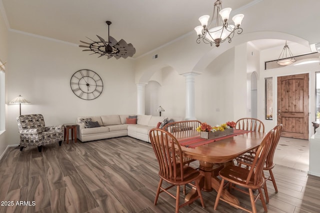 dining room featuring crown molding, arched walkways, ceiling fan, and wood finished floors