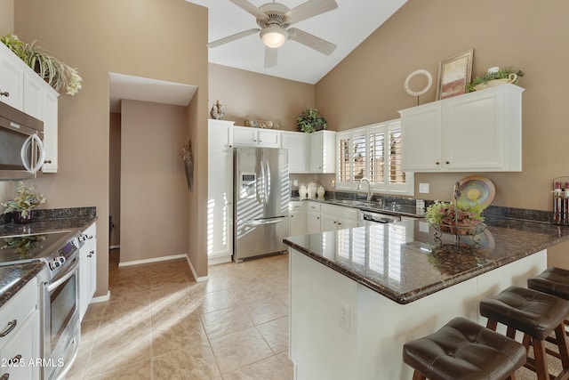 kitchen featuring white cabinetry, appliances with stainless steel finishes, sink, and a kitchen bar