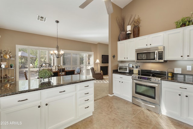 kitchen featuring pendant lighting, white cabinetry, stainless steel appliances, and dark stone counters