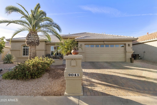 view of front of home with cooling unit and a garage